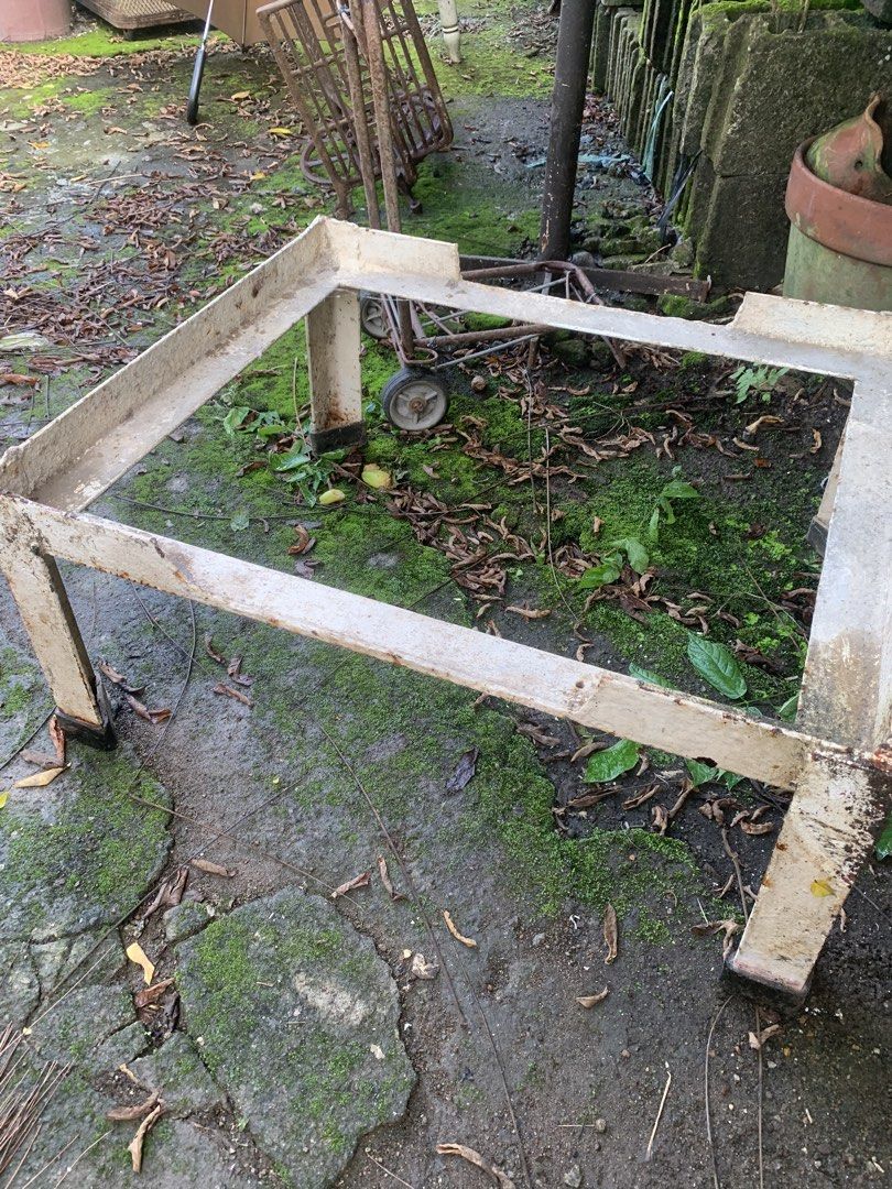 Sturdy metal stand frame for heavy equipment (Category: Construction Tools & Equipment) located in Quezon City. Submitted by sojisup (Listing ID 1468983778, Image 1). Description: Heavy-duty metal stand frame painted off-white. Square shape with four thick legs and corner cutouts on top. Paint is chipped and rusted in multiple spots from outdoor storage. Solid steel construction, weighs quite a bit. Great base for a custom table, planter, or work