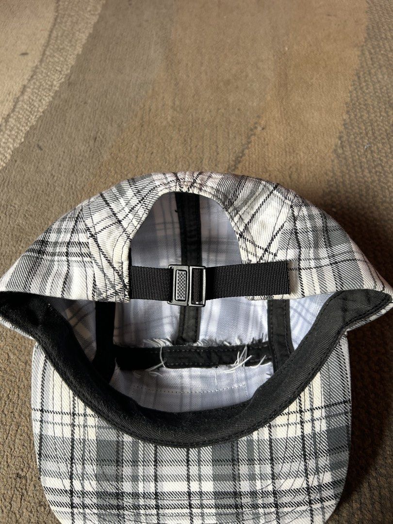 Supreme 2007 Plaid Camp Cap (Category: Caps & Hats) located in Abucay. Submitted by stuttt (Listing ID 1468995225, Image 3). Description: - Authentic Supreme 5-panel camp cap - Black and white plaid pattern with classic box logo patch - Adjustable black nylon strap with plastic buckle closure - Made in U.S.A. with interior tags intact - Note: Shows minor fraying along the interior sweatband seams.