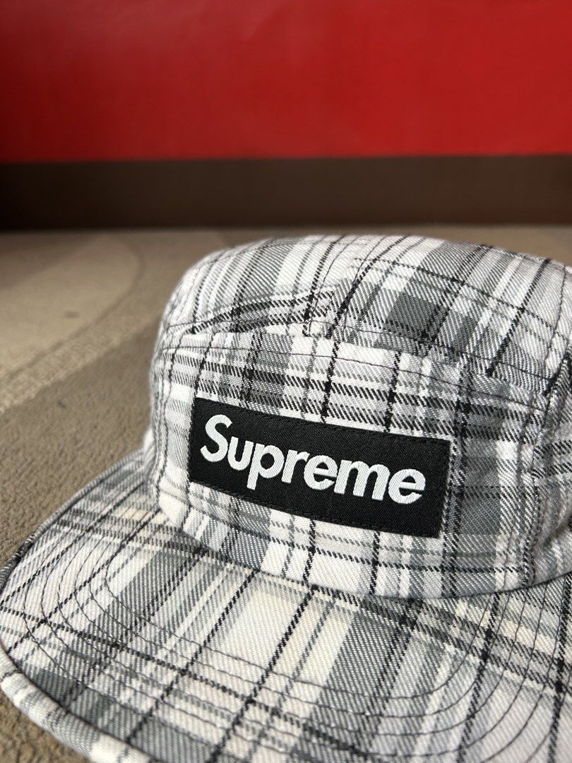Supreme 2007 Plaid Camp Cap (Category: Caps & Hats) located in Abucay. Submitted by stuttt (Listing ID 1468995225, Image 2). Description: - Authentic Supreme 5-panel camp cap - Black and white plaid pattern with classic box logo patch - Adjustable black nylon strap with plastic buckle closure - Made in U.S.A. with interior tags intact - Note: Shows minor fraying along the interior sweatband seams.