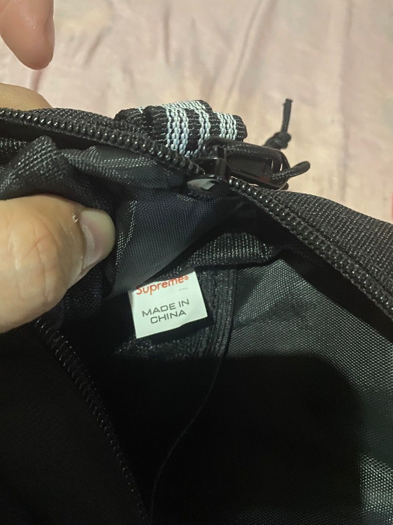 Supreme ss18 Black Shoulder Bag (Category: Sling Bags) located in Mabalacat. Submitted by zesko_ (Listing ID 1468992073, Image 3). Description: Black Supreme shoulder bag with durable canvas material. Red box logo tag stitched near the zipper. Adjustable strap with printed branding. Heavy-duty plastic buckle attached. Clean stitching along the seams and zipper track. Everyday carry size, great for daily use..