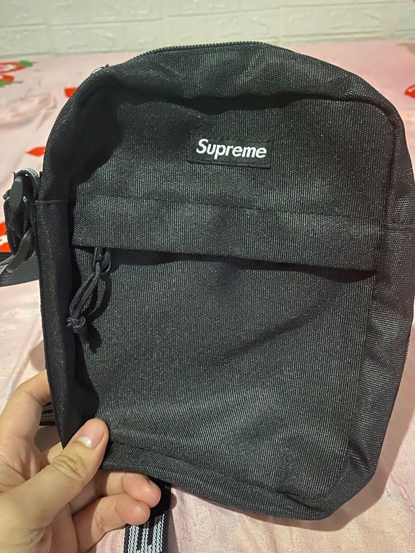 Supreme ss18 Black Shoulder Bag (Category: Sling Bags) located in Mabalacat. Submitted by zesko_ (Listing ID 1468992073, Image 1). Description: Black Supreme shoulder bag with durable canvas material. Red box logo tag stitched near the zipper. Adjustable strap with printed branding. Heavy-duty plastic buckle attached. Clean stitching along the seams and zipper track. Everyday carry size, great for daily use..