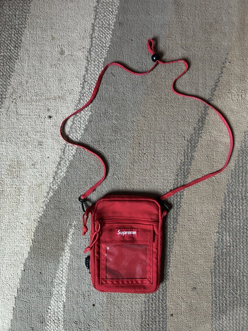 Supreme Red Cordura Utility Pouch Bag (Category: Sling Bags) located in Abucay. Submitted by stuttt (Listing ID 1468995667, Image 1). Description: - Brand: Supreme - Color: Vibrant bright red - Material: Durable Cordura fabric - Features: Clear ID window pocket, secure zippered main compartment, and adjustable cord strap with toggle lock - Origin: Made in China label inside - Condition: Clean, well-maintained, with no major flaws - Perfect for: H
