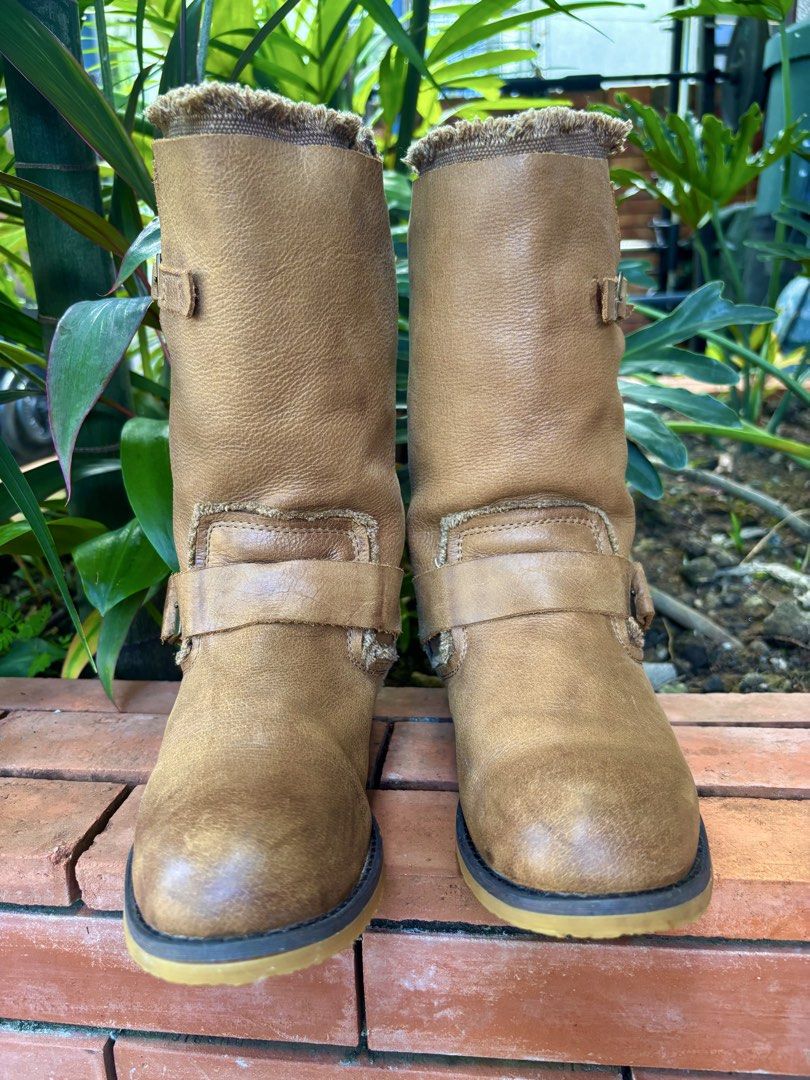 Tan Mid-Calf Leather Buckle Boots (Category: Boots) located in Paranaque City. Submitted by maishoppe17 (Listing ID 1468998388, Image 1). Description: - Women's boots - Bought in Bangkok - Mid-calf pull-on boots - Genuine Tan leather with frayed fabric collar trim - Dual buckle straps and elastic side gore panel (easy slip on) - Low heel with rubber grip - Rounded toe for comfort - Rubber sole in mint condition.