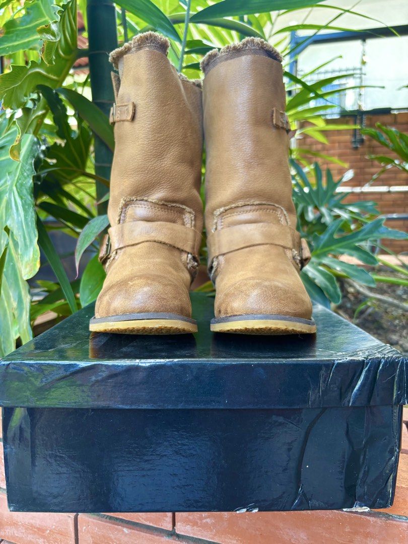 Tan Mid-Calf Leather Buckle Boots (Category: Boots) located in Paranaque City. Submitted by maishoppe17 (Listing ID 1468998388, Image 2). Description: - Women's boots - Bought in Bangkok - Mid-calf pull-on boots - Genuine Tan leather with frayed fabric collar trim - Dual buckle straps and elastic side gore panel (easy slip on) - Low heel with rubber grip - Rounded toe for comfort - Rubber sole in mint condition.