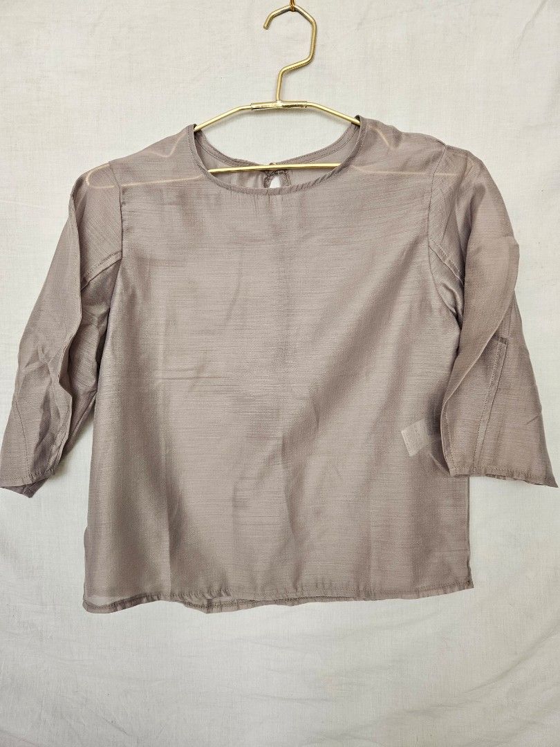 Taupe Three-Quarter Sleeve Blouse Round Neck (Category: Blouses) located in Quezon City. Submitted by _pcloset (Listing ID 1469005336, Image 1). Description: - Color: Taupe (Versatile neutral shade) - Sleeves: Three-quarter sleeves - Neckline: Round neck with back button closure - Fabric: Lightweight and smooth texture - Fit: Simple design with clean hem and cuffs.