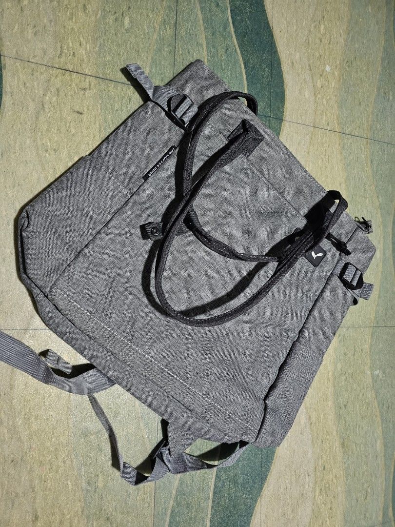 The Coffee Bean Grey Convertible Tote Backpack (Category: Backpacks) located in Dasmarinas. Submitted by jazvielle (Listing ID 1469086987, Image 1). Description: Grey canvas backpack from The Coffee Bean. Converts easily between a tote bag and a backpack with adjustable straps. Exterior front pocket with logo patch and zipper closure. Spacious main compartment inside lined in grey fabric. Clean inside and out, minor wear overall. Great everyday b