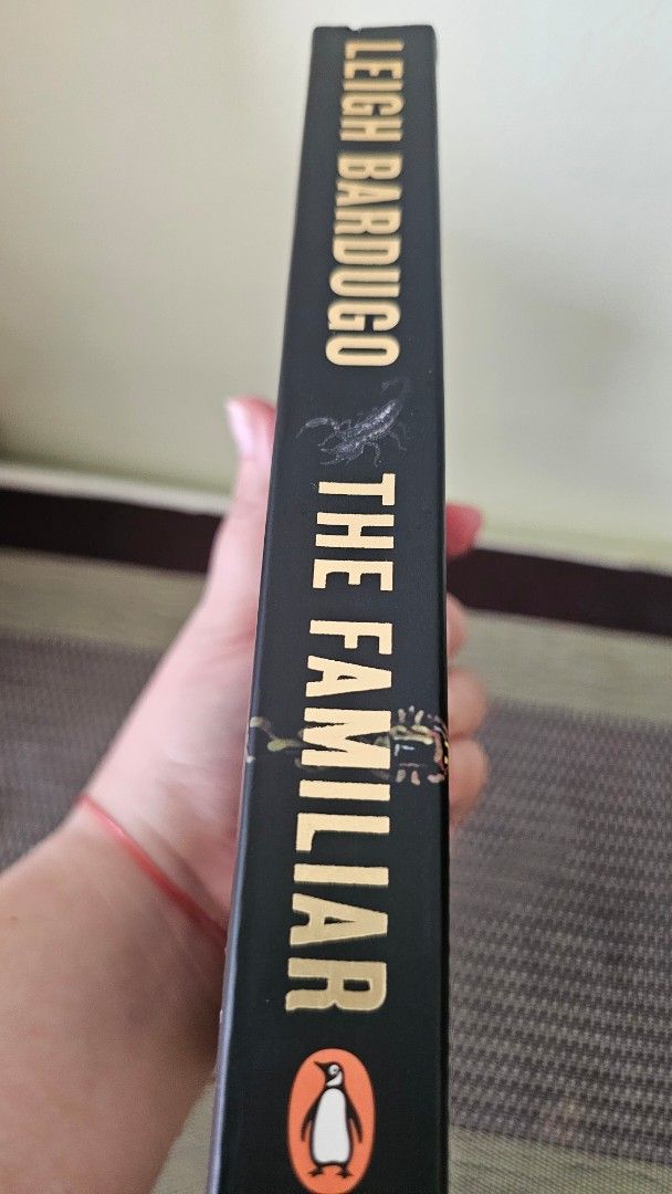 The Familiar by Leigh Bardugo Paperback (Category: Storybooks) located in Manila. Submitted by erikuhrox007 (Listing ID 1468982199, Image 3). Description: - Title: The Familiar by Leigh Bardugo - Publisher: Penguin Fiction - Format: Standard paperback with black cover and gold lettering - Condition: Read once, clean pages inside, minor yellowish stain on the top edge - Features: ISBN included on back cover - Genre: Bestselling fantasy read.