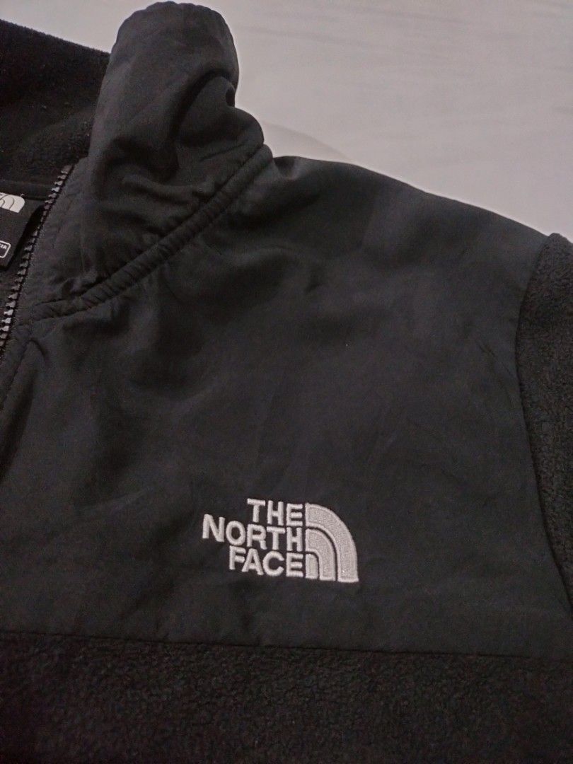 The North Face Black Fleece Jacket US M (Category: Coats, Jackets and Outerwear) located in Abucay. Submitted by naixrazion199x (Listing ID 1469155328, Image 3). Description: - Brand: The North Face - Color: Classic Black with contrast woven chest panel - Size: Men's US Medium / Asia Large - Material: 100% Polyester (Warm and cozy fleece) - Features: Full zip front, stand-up collar, and two secure zippered side pockets - Details: White embroidere