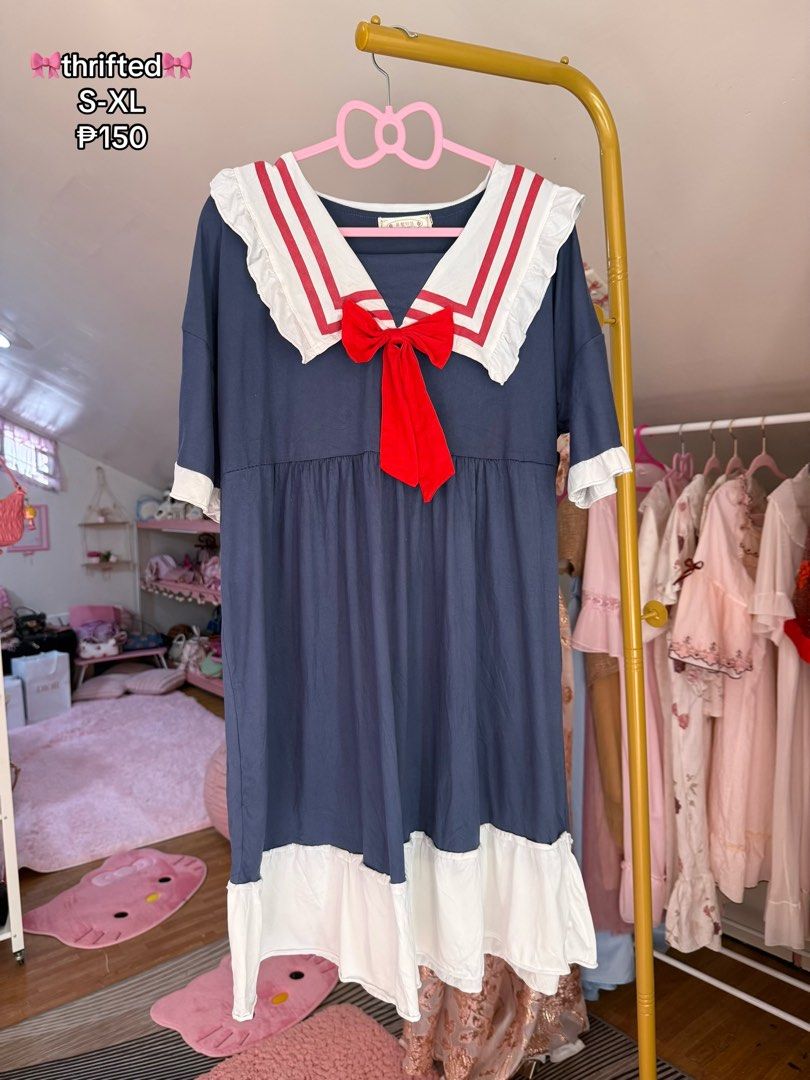 Thrifty Sailor Dress with Red Bow (Category: Dresses) located in Caloocan City. Submitted by fashionshop248 (Listing ID 1468952163, Image 1). Description: - Style: Thrifted sailor dress with dark blue, white, and red colorway - Design: Sailor collar with double red stripes, ruffled trim, and attached red ribbon bow - Details: Half sleeves with white cuffs and a white ruffled hem - Fit: Loose, comfortable everyday fit (fits sizes S to XL) - Vibe: 