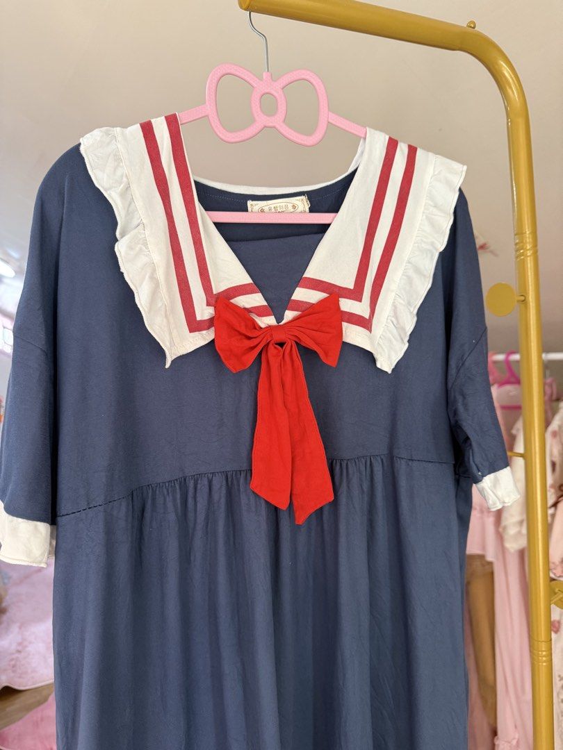 Thrifty Sailor Dress with Red Bow (Category: Dresses) located in Caloocan City. Submitted by fashionshop248 (Listing ID 1468952163, Image 2). Description: - Style: Thrifted sailor dress with dark blue, white, and red colorway - Design: Sailor collar with double red stripes, ruffled trim, and attached red ribbon bow - Details: Half sleeves with white cuffs and a white ruffled hem - Fit: Loose, comfortable everyday fit (fits sizes S to XL) - Vibe: 
