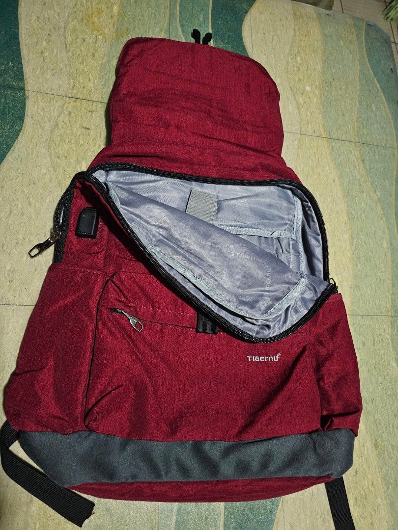 Tigernu Red Grey Laptop Backpack (Category: Backpacks) located in Dasmarinas. Submitted by jazvielle (Listing ID 1469085859, Image 3). Description: - Brand: Tigernu - Color: Red and Grey - Size: Roughly 16 to 17 inches - Laptop Compartment: Spacious main area with a secure velcro strap - Organization: Multiple zippered compartments and front pocket with built-in card slots and pen loops - Comfort & Durability: Durable fabric construction with adj