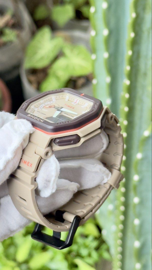 Timex Shock Analog Digital Tan Brown Watch (Category: Men's Watches) located in Manila. Submitted by junjun12356 (Listing ID 1469159383, Image 3). Description: - Brand: Timex Shock - Color: Tan and brown tones - Display: Analog hands with digital window - Strap: Durable resin strap with black buckle closure - Water Resistance: Up to 100 meters - Design: Octagon-shaped bezel with textured side pushers - Condition: Clean, handled with gloves.