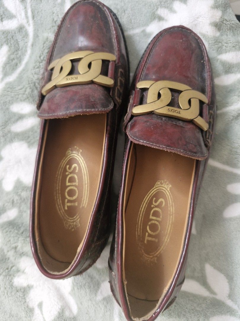 TOD'S Chain Link Burgundy Leather Loafers (Category: Loafers) located in Angeles City. Submitted by mycloset525clotheshoppe (Listing ID 1468931421, Image 1). Description: - Brand: TOD'S - Style: Burgundy leather loafers with slip-on design - Hardware: Elegant gold-tone chain link across the top - Interior: Tan leather lining with embossed logo on insoles - Condition: Regular wear with visible patina and scuffs on the leather upper; soles show typ