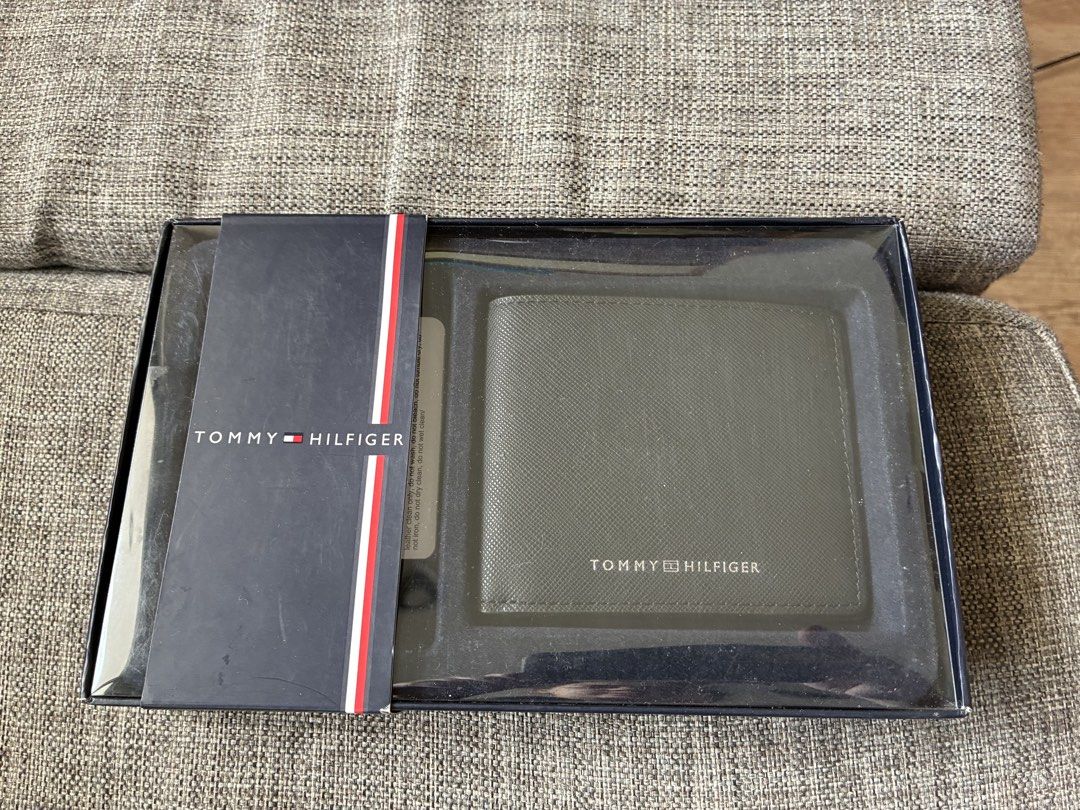 Tommy Hilfiger Bifold Wallet in Black Boxed (Category: Wallets & Card Holders) located in Paranaque City. Submitted by verosells (Listing ID 1469082315, Image 2). Description: - Brand: Tommy Hilfiger - Material: Black textured cow leather - Design: Bifold with card slots and cash compartment - Details: Classic red, white, and blue interior ribbon, stamped logo, and metal front lettering - Condition: Unused, pristine stitching, and clean corners -