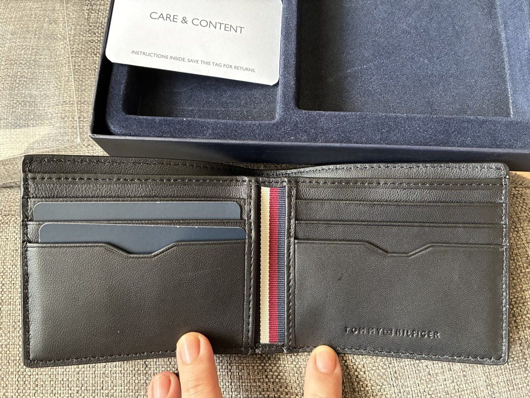 Tommy Hilfiger Bifold Wallet in Black Boxed (Category: Wallets & Card Holders) located in Paranaque City. Submitted by verosells (Listing ID 1469082315, Image 3). Description: - Brand: Tommy Hilfiger - Material: Black textured cow leather - Design: Bifold with card slots and cash compartment - Details: Classic red, white, and blue interior ribbon, stamped logo, and metal front lettering - Condition: Unused, pristine stitching, and clean corners -