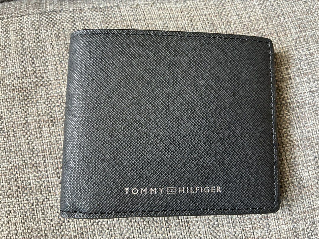 Tommy Hilfiger Bifold Wallet in Black Boxed (Category: Wallets & Card Holders) located in Paranaque City. Submitted by verosells (Listing ID 1469082315, Image 1). Description: - Brand: Tommy Hilfiger - Material: Black textured cow leather - Design: Bifold with card slots and cash compartment - Details: Classic red, white, and blue interior ribbon, stamped logo, and metal front lettering - Condition: Unused, pristine stitching, and clean corners -