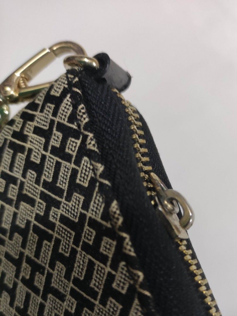 Tommy Hilfiger Monogram Wristlet Wallet (Category: Wallets & Card holders) located in Quezon City. Submitted by pprzi_89 (Listing ID 1469134982, Image 2). Description: pay for shipping fee - Brand: Tommy Hilfiger - Design: Black and beige monogram pattern with gold-tone hardware - Closure: Smooth zip-around closure - Interior: Multiple card slots and compartments lined with dark fabric - Extra Feature: Includes a detachable wrist strap (Note: not
