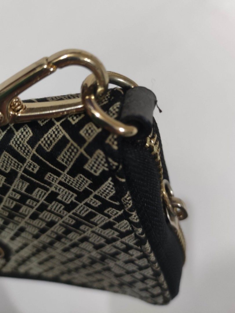 Tommy Hilfiger Monogram Wristlet Wallet (Category: Wallets & Card holders) located in Quezon City. Submitted by pprzi_89 (Listing ID 1469134982, Image 3). Description: pay for shipping fee - Brand: Tommy Hilfiger - Design: Black and beige monogram pattern with gold-tone hardware - Closure: Smooth zip-around closure - Interior: Multiple card slots and compartments lined with dark fabric - Extra Feature: Includes a detachable wrist strap (Note: not