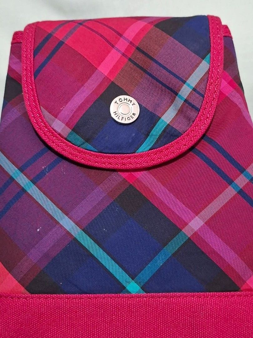 Tommy Hilfiger Pink Plaid Mini Backpack (Category: Backpacks) located in Manila. Submitted by closetprincess (Listing ID 1468958955, Image 2). Description: - Brand: Tommy Hilfiger - Style: Mini backpack - Pattern: Pink plaid with blue, purple, and turquoise lines - Trim: Solid hot pink along the base, straps, and flap edges - Hardware: Metal snap closure stamped with the brand logo - Straps: Adjustable webbed straps on the back - Interior: Black 