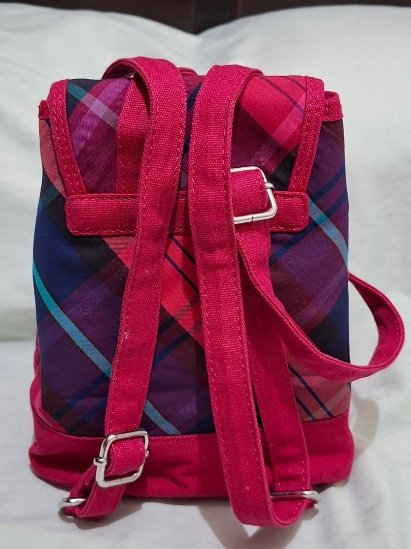 Tommy Hilfiger Pink Plaid Mini Backpack (Category: Backpacks) located in Manila. Submitted by closetprincess (Listing ID 1468958955, Image 3). Description: - Brand: Tommy Hilfiger - Style: Mini backpack - Pattern: Pink plaid with blue, purple, and turquoise lines - Trim: Solid hot pink along the base, straps, and flap edges - Hardware: Metal snap closure stamped with the brand logo - Straps: Adjustable webbed straps on the back - Interior: Black 