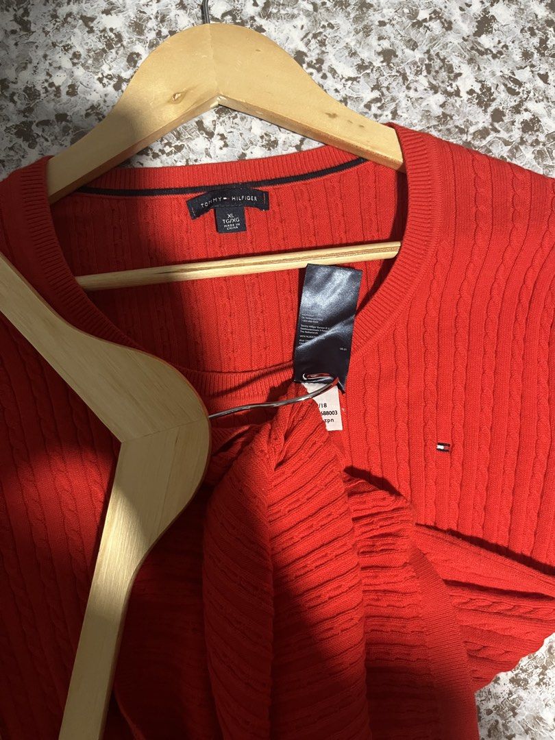 Tommy Hilfiger Red Cable Knit Sweater (Category: Coats, Jackets and Outerwear) located in Maasin. Submitted by niconii090 (Listing ID 1468985629, Image 3). Description: - Brand: Tommy Hilfiger - Style: Cable knit crew neck sweater - Color: Bright red - Details: Long sleeves, ribbed trim, small embroidered flag logo on left chest - Material: Soft cotton knit texture -📏 20 x 26 (inches).