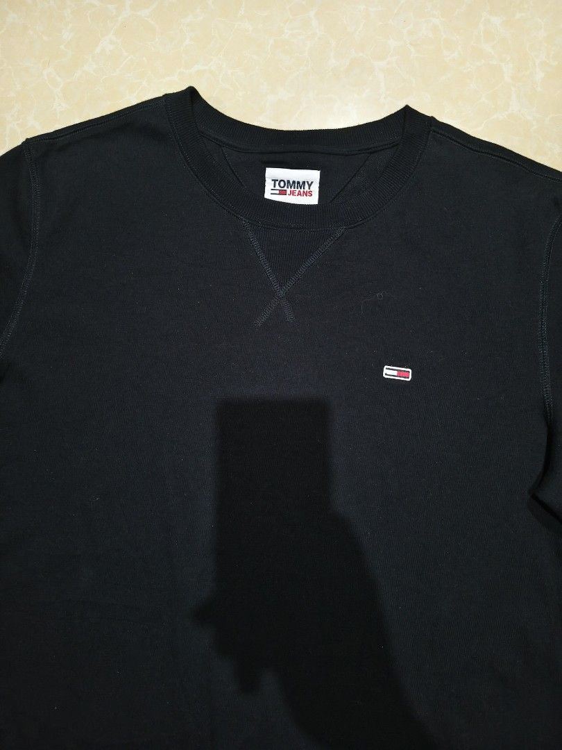 Tommy Jeans Black Sweatshirt Size XL (Category: Coats, Jackets and Outerwear) located in Manila. Submitted by purefire-477a (Listing ID 1469078127, Image 3). Description: - Brand: Tommy Jeans - Color: Black - Size: XL - Material: Cotton-polyester blend - Design: Crew neck with V-stitch detail and small chest logo embroidery - Fit: Classic fit with ribbed cuffs and hem - Measurements: Width 22" x Length 28" - Origin: Made in China.