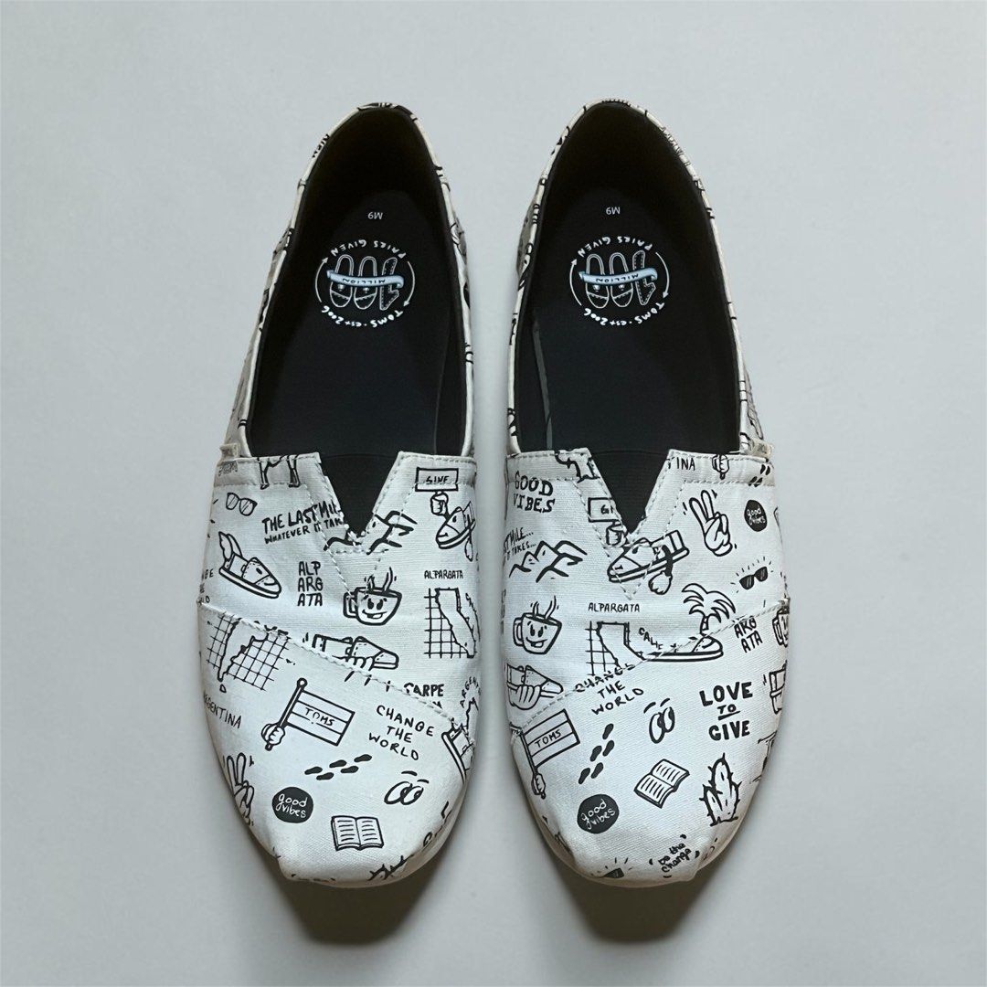 Toms Alpargata Slip-Ons Size 9 (Category: Slippers & Slides) located in Manila. Submitted by chococoffeeboy (Listing ID 1468995566, Image 1). Description: - Toms Alpargata canvas slip-on shoes - Design: White with all-over black doodle sketches, text graphics, and palm tree drawings - Condition: Clean insoles with light wear on the outer soles - Perfect for: Easy, casual everyday outfits Payment: Gcash/Maya Buyer shoulders shipping .