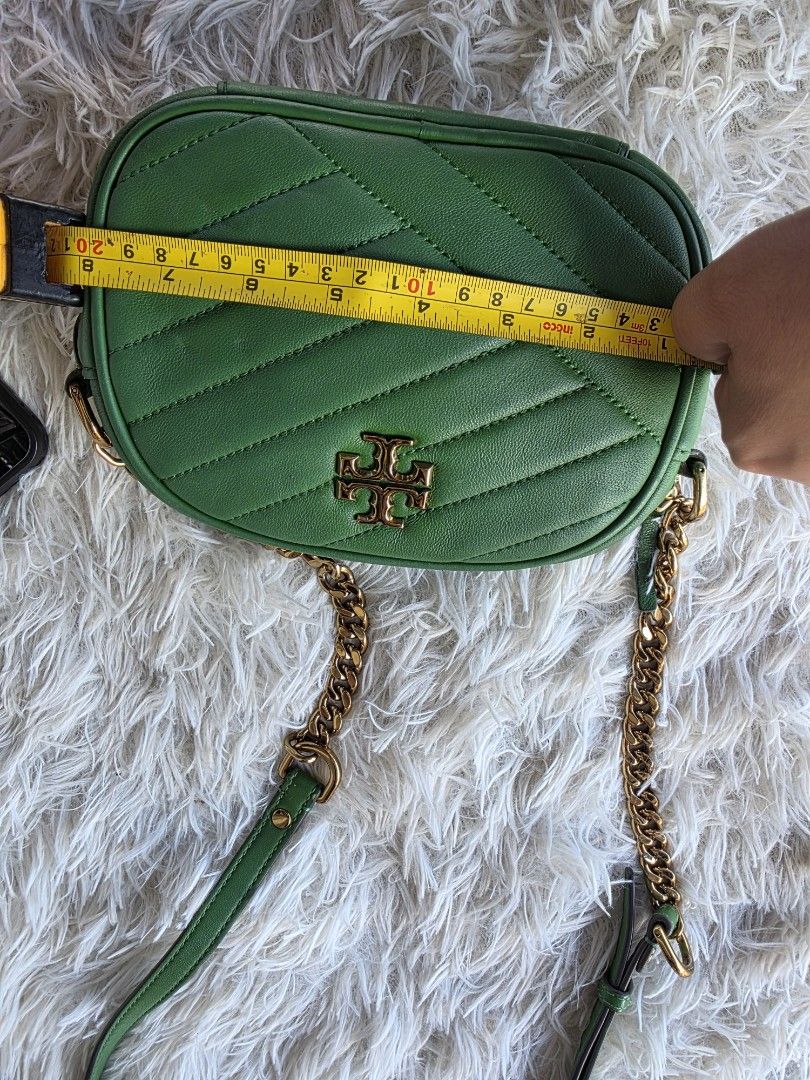 Tory Burch Green Kira Chevron Camera Bag (Category: Cross-body Bags) located in Lemery. Submitted by venus23 (Listing ID 1468930538, Image 3). Description: - Tory Burch camera bag in a stunning green shade - Crafted from premium leather with chic chevron quilting - Elegant gold-tone hardware and prominent front logo - Secure zip top closure - Measures approximately 7.5 inches across - Stylish mixed chain and leather strap - Roomy enough for your 