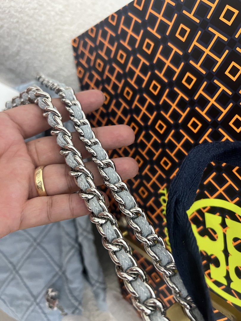 Tory Burch Quilted Denim Shoulder Bag (Category: Shoulder Bags) located in Abulug. Submitted by jamiecammie (Listing ID 1468993399, Image 3). Description: - Brand: Tory Burch - Style: Quilted denim shoulder bag - Color: Light blue with silver hardware - Strap: Silver chain interwoven with denim fabric (protective wrapping still attached) - Condition: Unused, brand new - Features: Spacious interior and soft quilted texture - Inclusions: Dust bag a