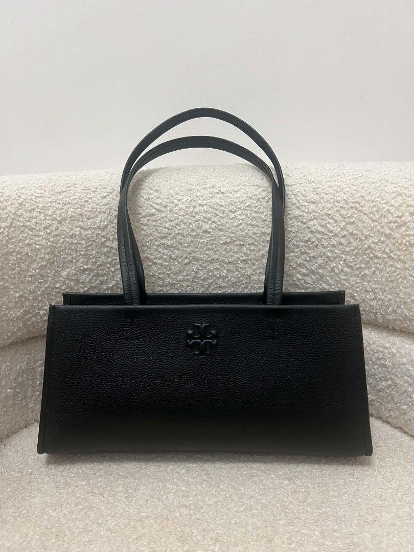 Tory Burch Thea East West Shoulder Bag (Category: Shoulder Bags) located in Paoay. Submitted by rvf1230 (Listing ID 1468545544, Image 1). Description: - Authentic Tory Burch black leather shoulder bag - Structured rectangular shape with a minimalist design - Subtle debossed logo on the front face - Comfortable thin shoulder straps - Clean edge and base stitching - Spacious interior for all your daily essentials - Condition: Excellent / Grab it be