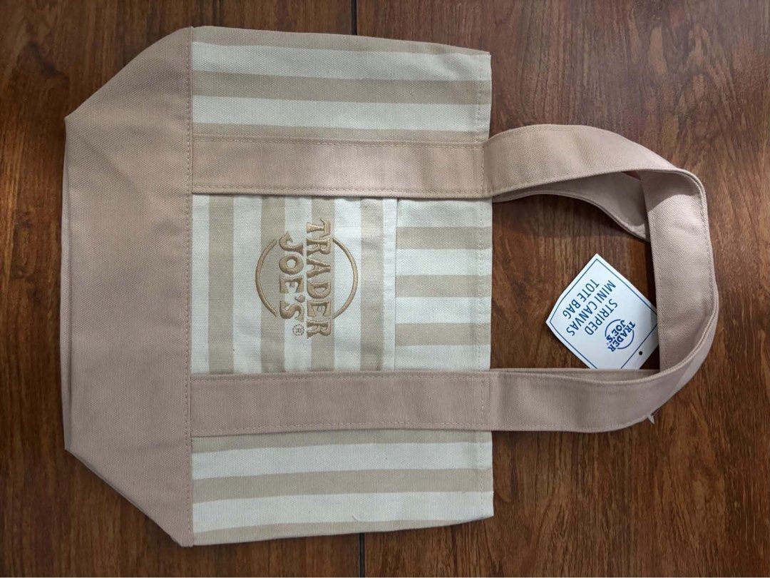 Trader Joe's Mini Canvas Tote Bag (Category: Tote Bags) located in Marilao. Submitted by pinhail (Listing ID 1469060316, Image 3). Description: s: 620 l: 799 - Authentic Trader Joe's mini canvas tote bags - Available colors: Striped green, plain purple, striped pink, and striped beige - Features: Small handles and a convenient front pocket with embroidered logo - Condition: Brand new with original paper tags attached on two of them - Perfect size