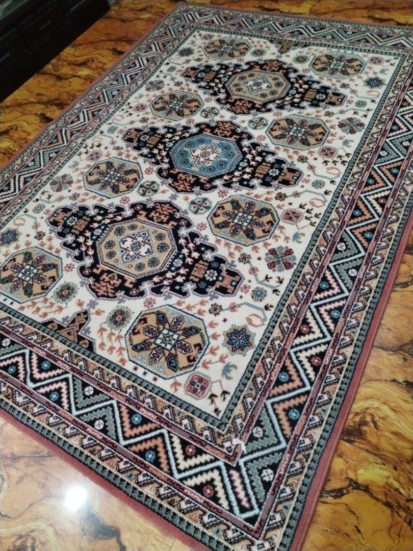 Traditional patterned area rug with geometric border (Category: Carpets, Mats & Flooring) located in Caloocan City. Submitted by rowely_jpn (Listing ID 1469099686, Image 2). Description: Japan surplus Area rug with intricate geometric and medallion patterns. Cream background with navy, blue, beige, and terracotta accents. Detailed zig-zag border design along the edges. Soft pile texture. Clean condition with no stains or damage visible. Ready to 