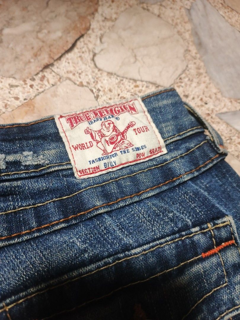 True Religion (Category: Jeans) located in Bulacan. Submitted by thriftinggss_jm (Listing ID 1469036142, Image 3). Description: - Brand: True Religion - Style: Billy Fit (Straight Leg) - Size: 25 - Color: Classic Blue Wash - Origin: Made in USA - Details: Iconic horseshoe flap pockets with button closures, classic contrast stitching, waistband tag intact.