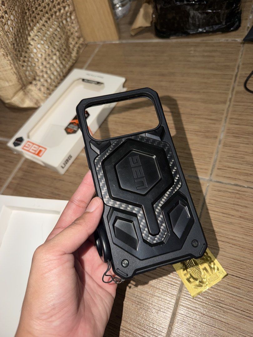 UAG Monarch Pro 17 Promax (Category: Cases & Sleeves) located in Taguig. Submitted by zelpremo (Listing ID 1469085823, Image 1). Description: - Brand/Model: UAG Monarch Pro - Compatibility: iPhone 17 Pro Max - Color: Black with carbon fiber accents - Condition: Excellent, lightly used with original box included - Features: Heavy-duty rugged drop protection, precise cutouts, tactile buttons, and built-in lanyard anchor - Fulfillment: Available for