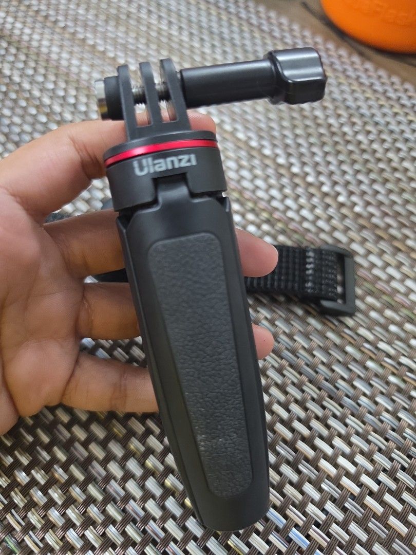Ulanzi hand grip and Flymile remote control (Category: Tripods & Monopods) located in Quezon City. Submitted by littlemissrafaella (Listing ID 1468963031, Image 2). Description: - Brand/Item: Ulanzi black hand grip with standard action camera mount - Included: Flymile black remote controller with power, sync, and red record buttons - Convenience: Attached to a secure black fabric wrist strap with buckle closure - Condition: Clean and well-maintai