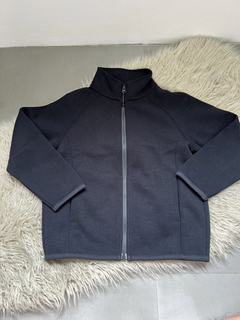 Uniqlo Black Zip-Up Jacket Size 110 (Category: Babies & Kids Fashion) located in Binan City. Submitted by finders_market (Listing ID 1468944873, Image 1). Description: - Brand: Uniqlo Kids - Size: 110 - Color: Solid black - Design: Full zip-up closure, high mock neck collar, and long raglan sleeves - Feature: Small reflective logo near the bottom hem for added visibility - Material: Smooth, stretchy, and lightweight fabric - Condition: Excellent 