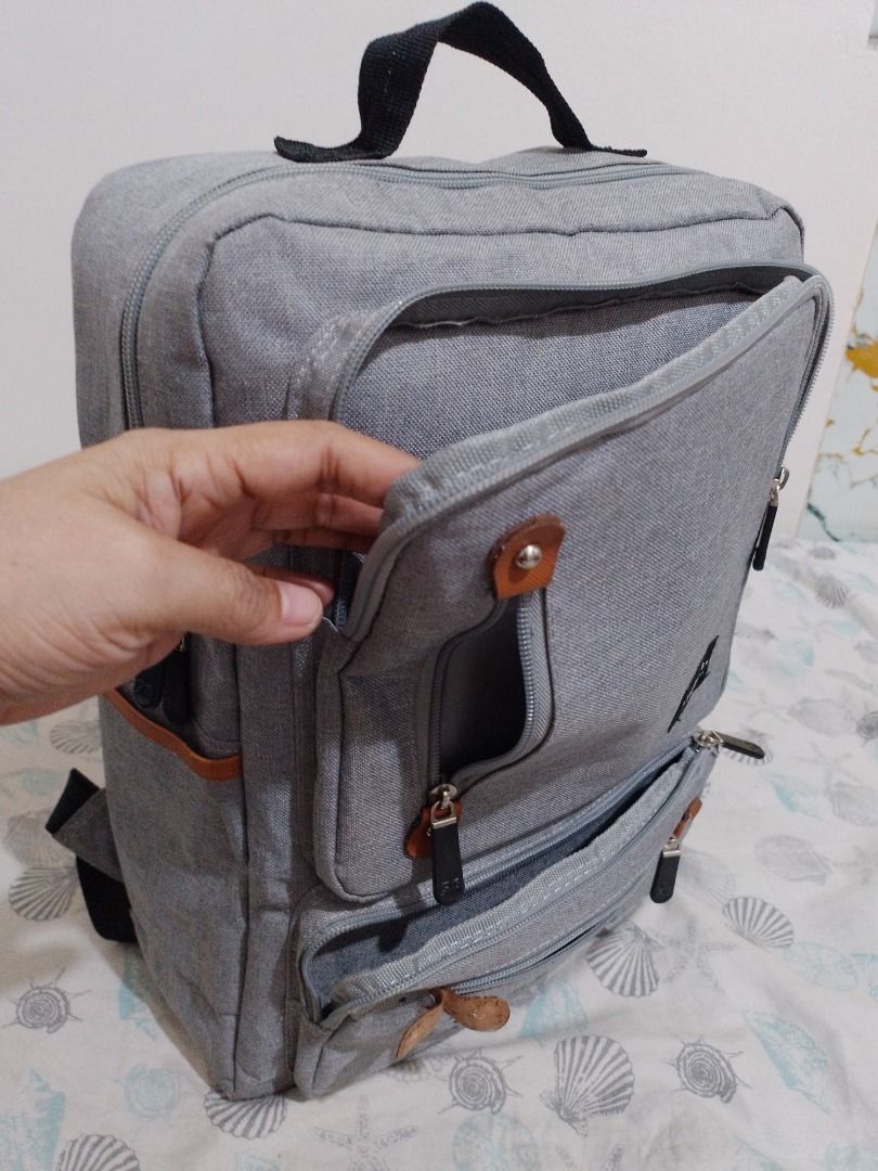 Veloche Grey Canvas Laptop Backpack (Category: Backpacks) located in Imus. Submitted by bestfinds_yeth0724 (Listing ID 1469153579, Image 3). Description: Grey canvas backpack from Veloche. Has brown faux leather accents, multiple zippered exterior pockets, and a top grab handle. Inside has a padded laptop sleeve with a velcro strap. Back straps are adjustable and padded. Korean text printed on the lower front pocket. MOP gcash Issue; please refer
