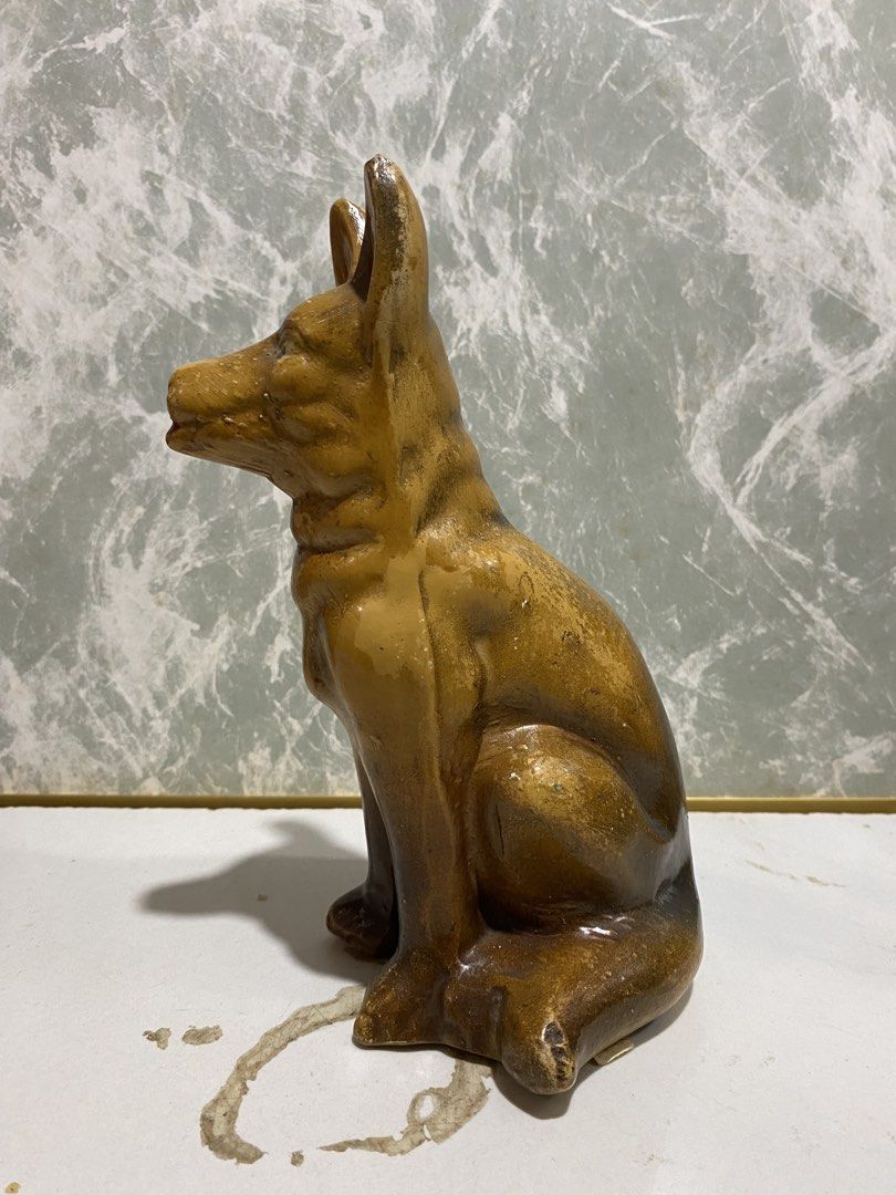Vintage German Shepherd Ceramic Dog Statue (Category: Figurines & Statues) located in Calamba. Submitted by chebvintagedepot (Listing ID 1469027921, Image 3). Description: (B27-03) Vintage brown glazed ceramic or porcelain figurine of a German Shepherd sitting upright, with pointed ears and a red tongue. A nice decorative piece for dog lovers or collectors of vintage animal figurines. A lovely little piece to display on a shelf, desk, or in a col