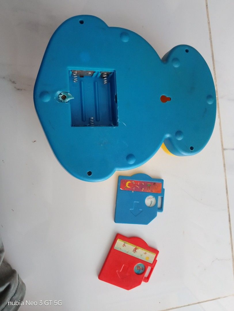 Vintage Jollibee Toy Projector with Slides (Category: Kids Toys) located in Manila. Submitted by wilmen14 (Listing ID 1468949193, Image 2). Description: - Vintage Jollibee toy projector in yellow and blue - Features a classic mascot graphic with a rainbow and stars - Includes two slide cartridges (blue and red) - Requires 3 batteries for operation - Shows minor signs of wear and age on stickers and plastic - Perfect collectible piece for Jollibee