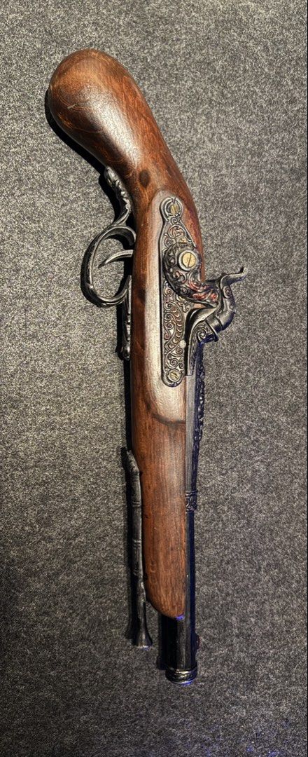 Vintage LIGHTER Replica Flintlock Pirate Pistol (Category: Vintage Collectibles) located in Manila. Submitted by grandpenguin0925 (Listing ID 1469157377, Image 3). Description: - Type: Decorative flintlock pistol LIGHTER - Finish: Wood grain stock with ornate metal engravings - Features: Working hammer mechanism, brass-tone screws, and attached ramrod - Material: Solid weight, highly detailed casting Working flint/ignition Need lighter fluid/buta