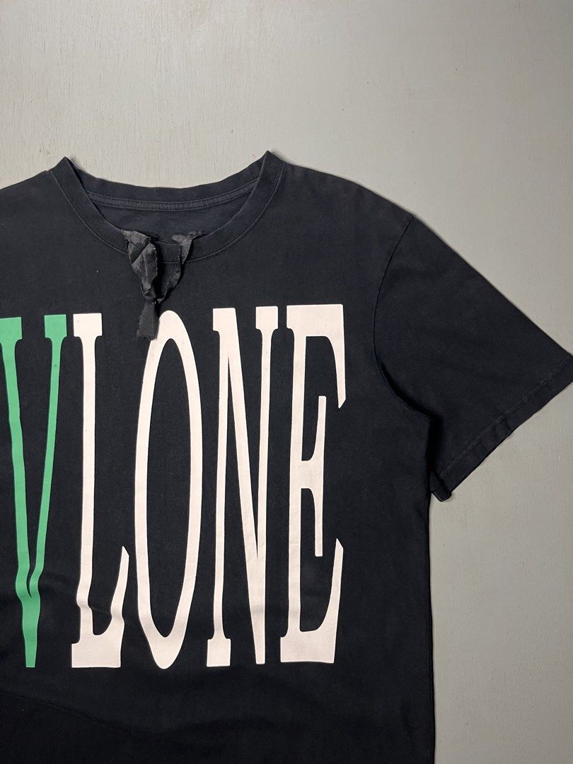 Vlone Green and White Logo (Category: Tshirts & Polo Shirts ) located in Catbalogan. Submitted by yellfindss (Listing ID 1469132513, Image 3). Description: - Color: Black with green and white graphics -21/28 - Design: Large vertical Vlone front print and signature big green V logo on the back - Details: Unique black fabric ribbon attached near the front collar - Material: Soft, premium cotton for daily comfort - Fit: Standard crew neck, regular f