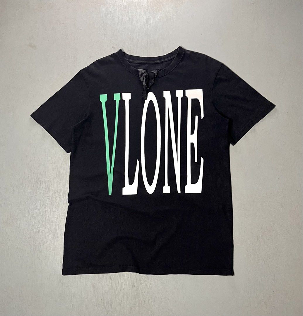 Vlone Green and White Logo (Category: Tshirts & Polo Shirts ) located in Catbalogan. Submitted by yellfindss (Listing ID 1469132513, Image 1). Description: - Color: Black with green and white graphics -21/28 - Design: Large vertical Vlone front print and signature big green V logo on the back - Details: Unique black fabric ribbon attached near the front collar - Material: Soft, premium cotton for daily comfort - Fit: Standard crew neck, regular f