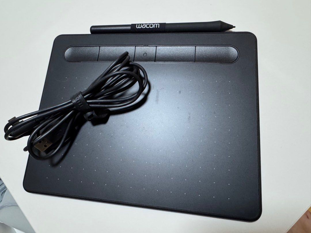 Wacom Intuos Drawing Tablet with Pen and USB Cable (Category: Other Accessories) located in Pasig City. Submitted by omeeom (Listing ID 1468950167, Image 1). Description: - Wacom Intuos Graphic Tablet in Matte Black - Condition: Fully functional with normal signs of use on the drawing surface - Included Accessories: Pressure-sensitive stylus pen and USB cable with strap - Features: 4 customizable ExpressKeys and dot-pattern active drawing area - 
