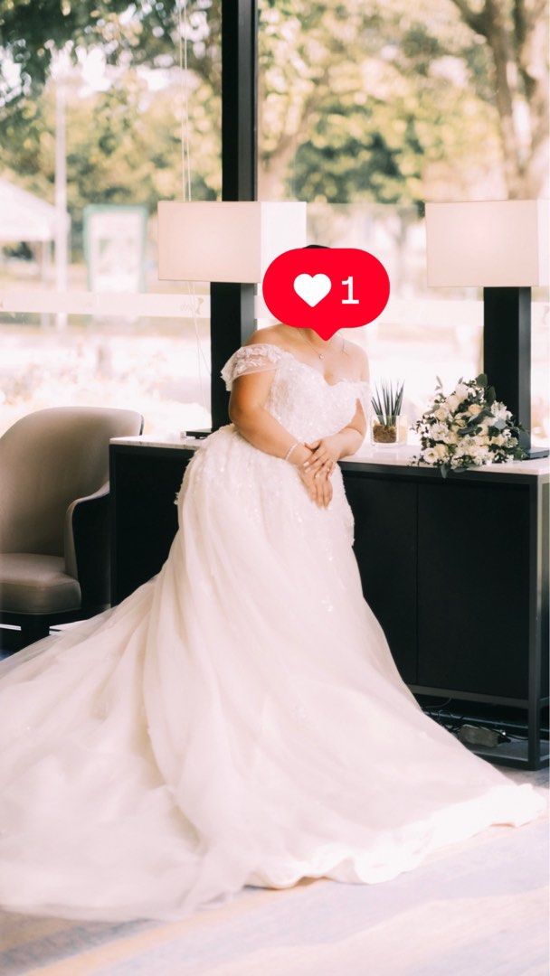 Wedding Gown (Paulo Baltazar) (Category: Evening dresses & gowns) located in Cavite. Submitted by item10001 (Listing ID 1469037554, Image 1). Description: Designer: Paulo Baltazar Style: Off-shoulder A-line / Ballgown with delicate lace details and tulle train Color: Off-white / Ivory Condition: Excellent / Professionally dry-cleaned Size: Fits Large Inclusions: Includes matching veil.