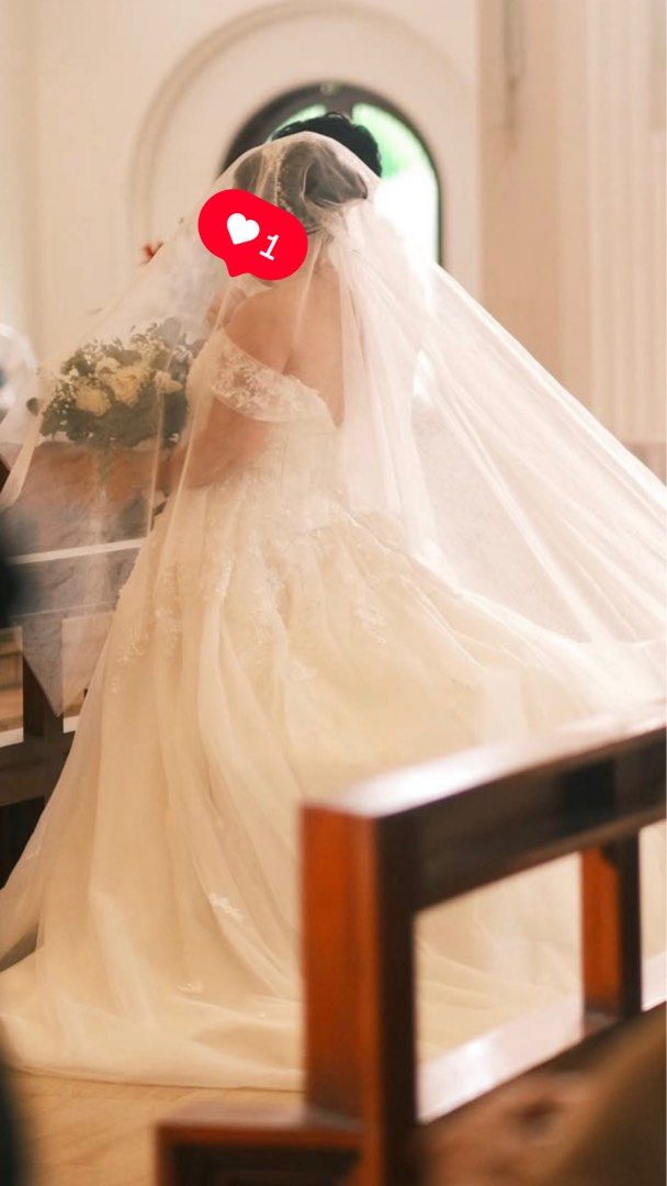 Wedding Gown (Paulo Baltazar) (Category: Evening dresses & gowns) located in Cavite. Submitted by item10001 (Listing ID 1469037554, Image 3). Description: Designer: Paulo Baltazar Style: Off-shoulder A-line / Ballgown with delicate lace details and tulle train Color: Off-white / Ivory Condition: Excellent / Professionally dry-cleaned Size: Fits Large Inclusions: Includes matching veil.