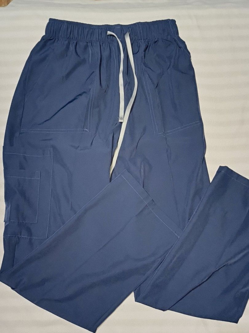 WENURSE Navy Blue Scrubs Set Size S (Category: Sets or Coordinates) located in Taguig. Submitted by yunisya_ (Listing ID 1469033035, Image 3). Description: - Brand: WENURSE - Color: Navy Blue - Size: Small - Top: Half-zip neckline with multiple front pockets - Pants: Elastic drawstring waistband with cargo pockets - Condition: Clean, well-kept, and comfortable - Ideal for: Nurses, medical staff, and healthcare workers.