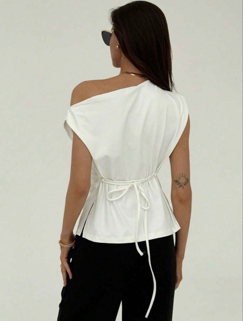 White Asymmetric One-Shoulder Draped Top with Back Tie (Category: Sleeveless) located in Bulacan. Submitted by 35mm_ (Listing ID 1469005821, Image 2). Description: - Style: Asymmetric one-shoulder sleeveless top - Color: Clean solid white - Features: Draped fabric with thin back waist tie for a cinched fit - Versatility: Easy to pair with black trousers, denim, or skirts - Condition: Brand new / Excellent - Mode of Payment: GCash / Bank Transfer 