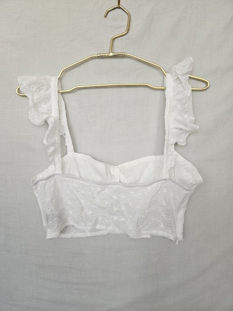 White Eyelet Crop Top with Ruffle Straps (Category: Sleeveless) located in Quezon City. Submitted by _pcloset (Listing ID 1469005326, Image 2). Description: - Color: White - Design: Eyelet embroidery with wide ruffled straps and square neckline - Fit: Short crop cut, lightweight fabric - Styling: Great with high-waisted denim or skirts - Condition: Clean and well-maintained.