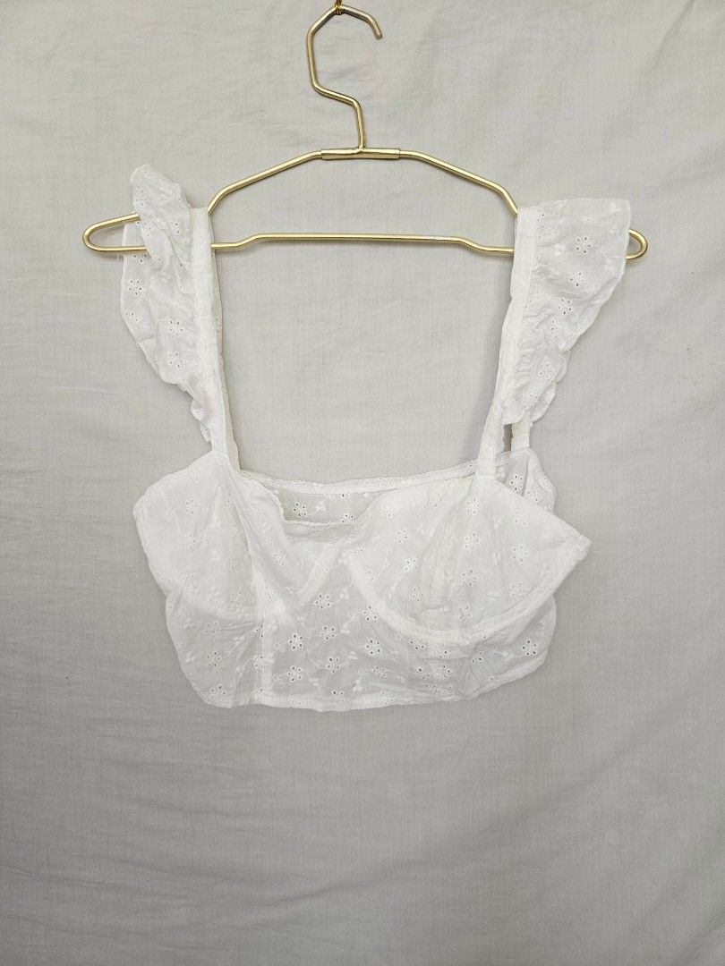 White Eyelet Crop Top with Ruffle Straps (Category: Sleeveless) located in Quezon City. Submitted by _pcloset (Listing ID 1469005326, Image 1). Description: - Color: White - Design: Eyelet embroidery with wide ruffled straps and square neckline - Fit: Short crop cut, lightweight fabric - Styling: Great with high-waisted denim or skirts - Condition: Clean and well-maintained.