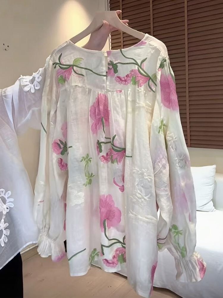 White Floral Embroidered Long Sleeve Blouse (Category: Longsleeves) located in Taguig. Submitted by mengxir20193848 (Listing ID 1468988421, Image 2). Description: - Color: White with pink and green floral embroidery - Material: Sheer textured fabric with subtle floral patterns - Design: Round neckline, back button closure, and ruffled sleeve cuffs - Fit: Loose and flowy - Perfect for: Spring outfits and casual chic looks.